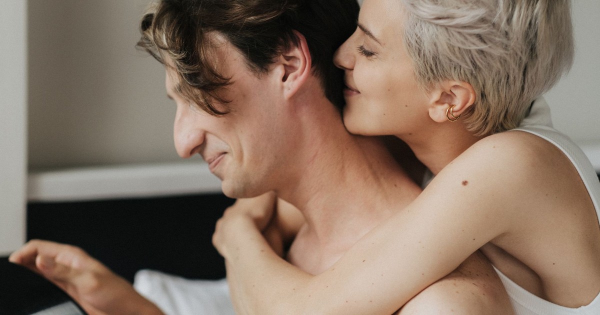A loving couple embraces tenderly in a cozy indoor setting, showcasing intimacy and connection.