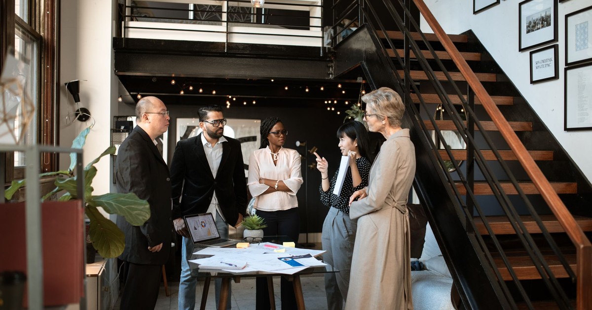 Diverse professionals engaged in a meeting in a stylish modern office setting.