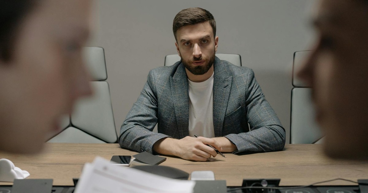 Serious businessmen engaged in a formal meeting around a conference table.