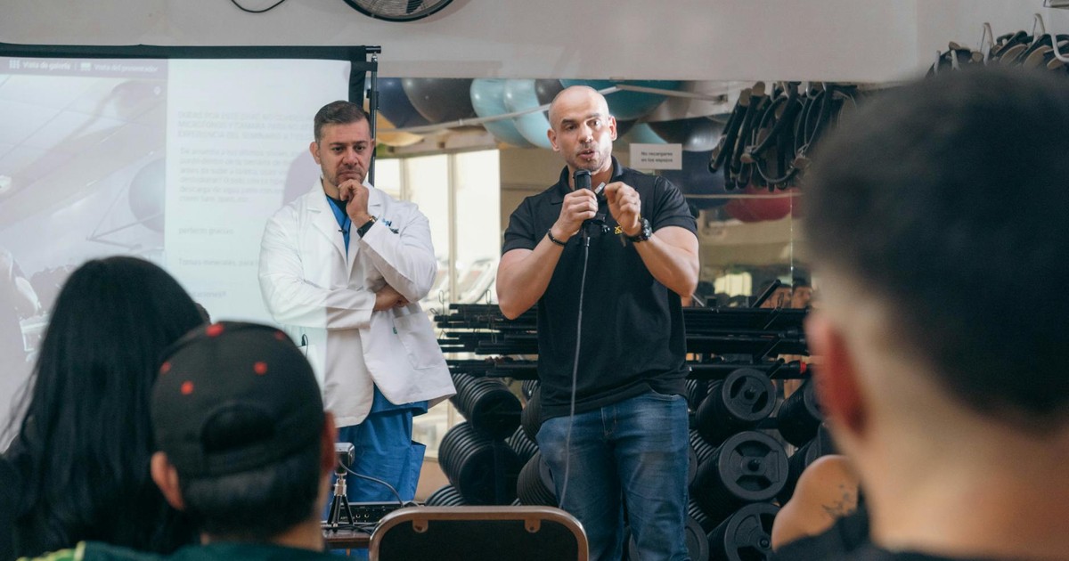 A doctor and fitness trainer conducting a seminar in a gym setting.