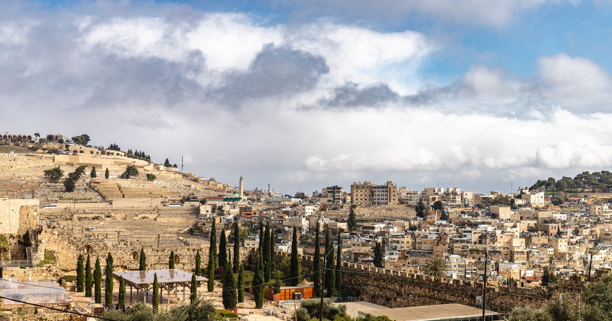 A panoramic view of Jerusalem's historic skyline under a vibrant sky.