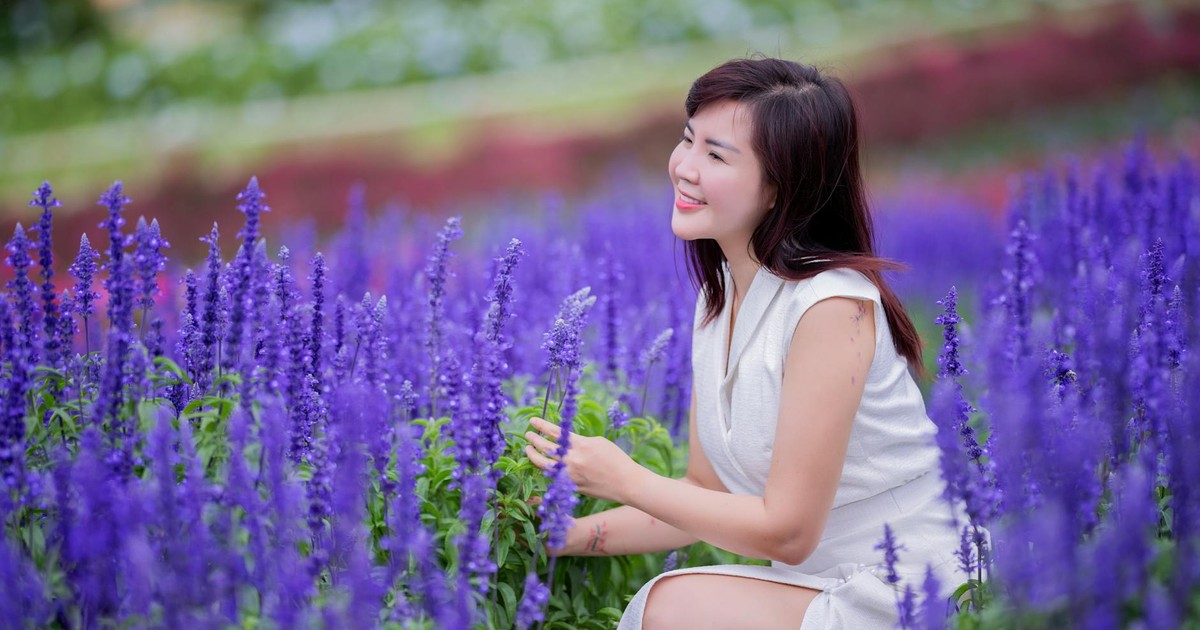A woman in a white dress enjoys a sunny day surrounded by lavender flowers, capturing the essence of summer.