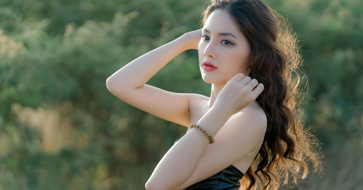 Portrait of a woman with long hair and elegant dress captured outdoors in natural light, conveying a serene mood.