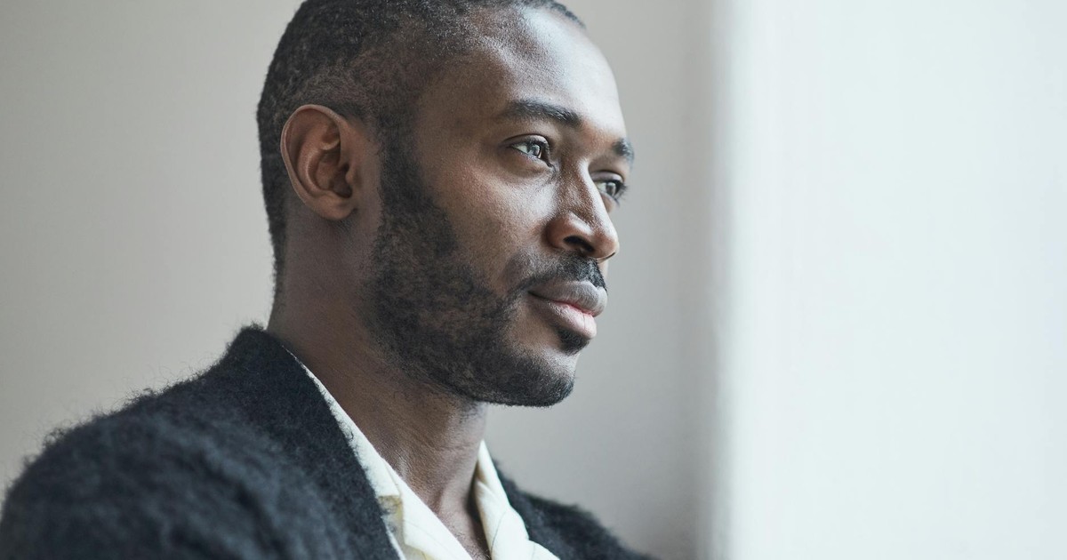 Portrait of a thoughtful adult man gazing out a window, invoking deep reflection.