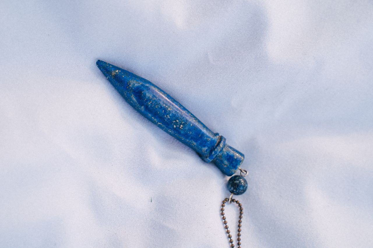 Close-up of a blue crystal pendant on a keychain with a metallic chain