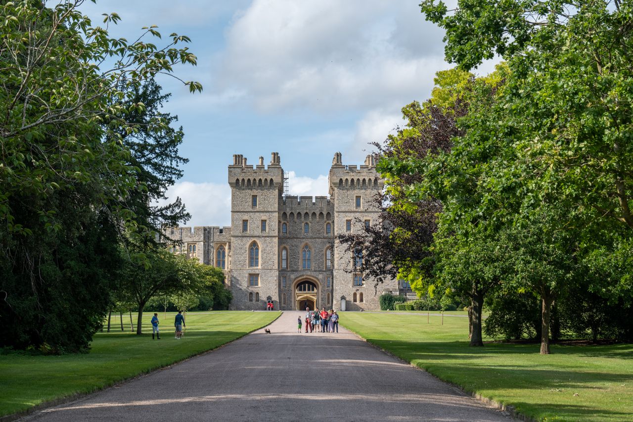 Charming scene of Windsor Castle surrounded by lush greenery and visitors.