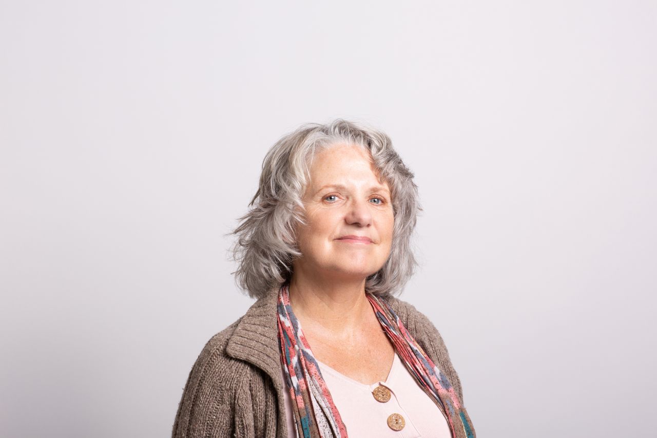 woman smiling in brown shirt