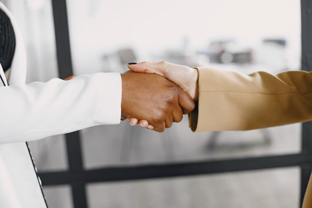 Close-up of a handshake between diverse business professionals indoors