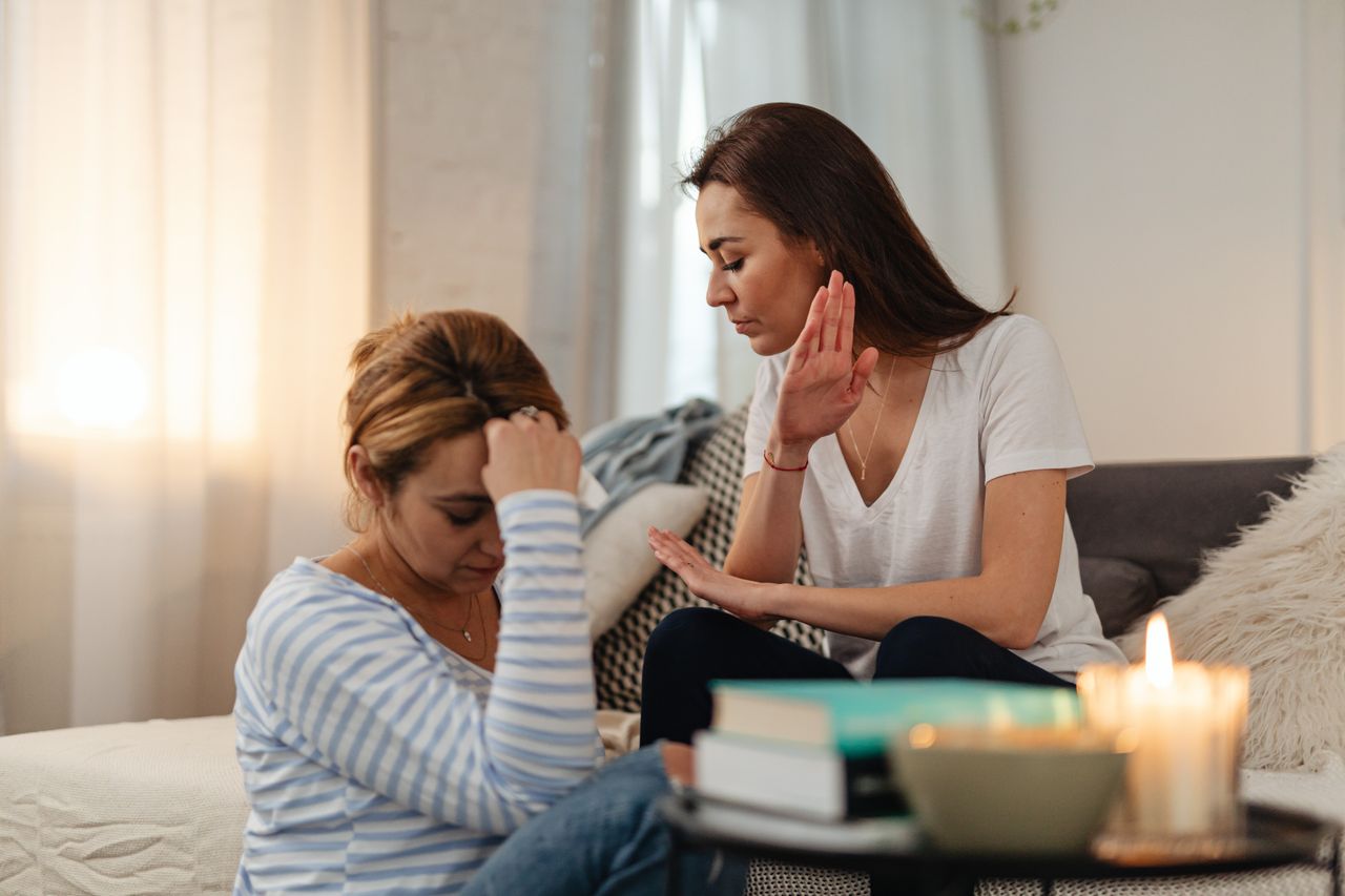 Two women in a tense emotional exchange in a cozy home setting