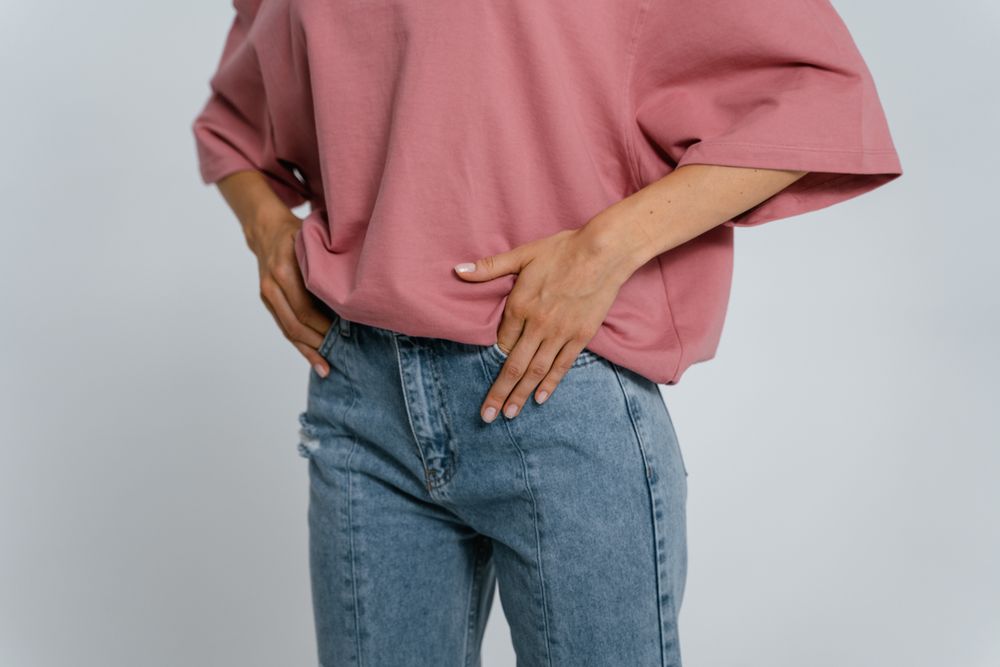 Stylish outfit featuring a pink oversized t-shirt and blue denim jeans in a studio setting