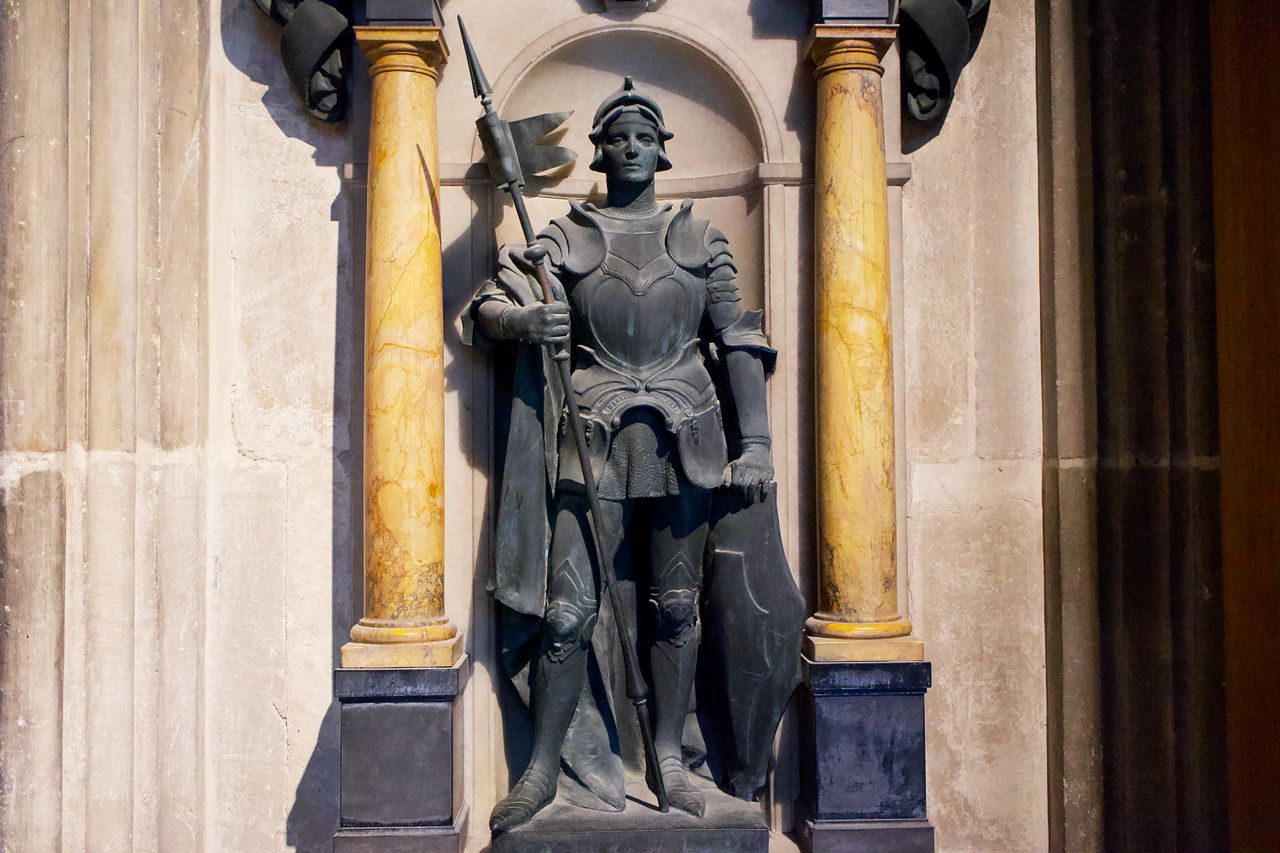 Detailed statue of a medieval knight in an English cathedral alcove