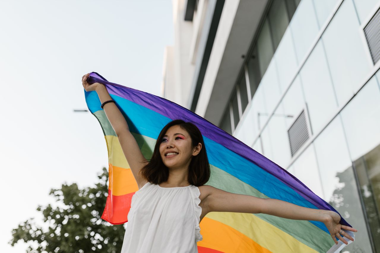 woman holding pride flag outdoors