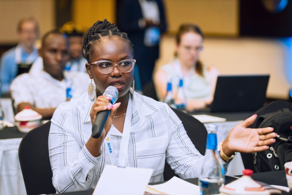 Woman speaking into a microphone during a business conference, engaging with audience