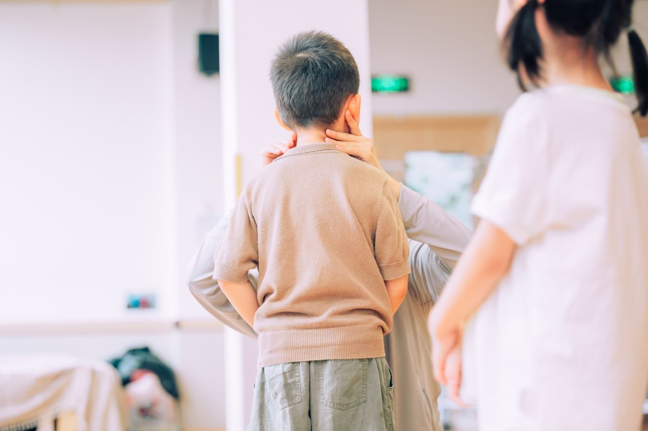 Young child being examined by a medical professional in a healthcare environment