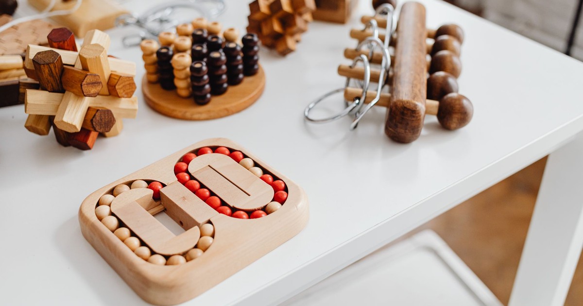 A collection of wooden brain teasers and puzzles on a table, showcasing various designs and structures.
