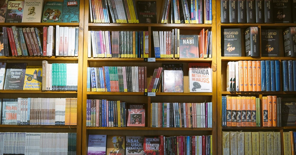A wide view of bookshelves filled with various books, showcasing knowledge and diversity in a library setting.