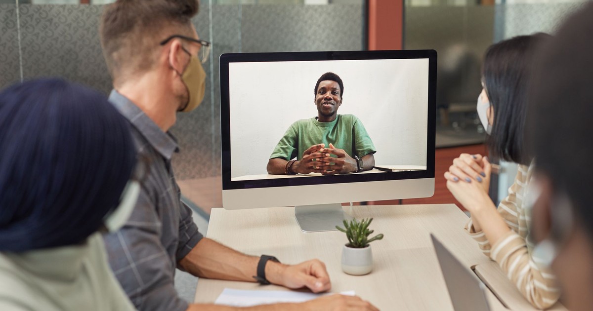 A diverse group having a video conference meeting in an office setting, promoting teamwork and collaboration.