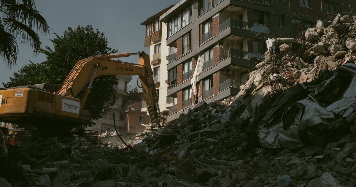 Excavator removing rubble from a collapsed building area in Antakya, Türkiye.