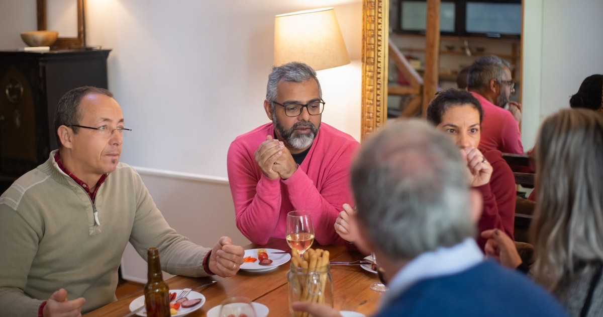 A family enjoying a casual meal indoors, sharing food and conversation.