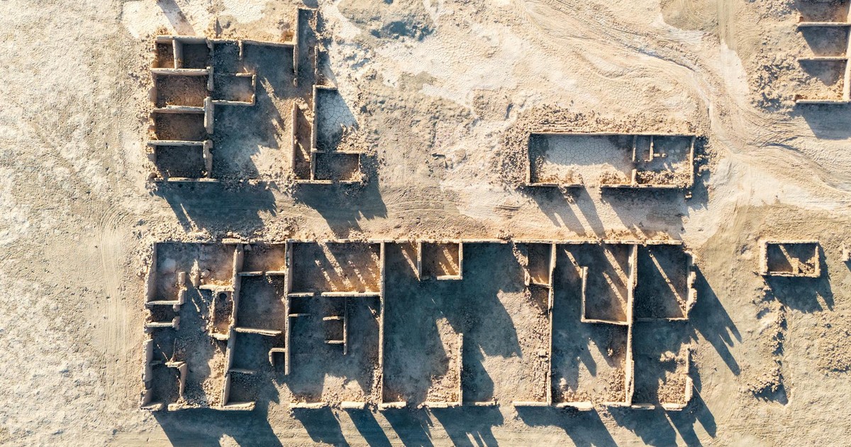 Aerial shot capturing the intricate layout of ancient ruins in a sandy desert setting.