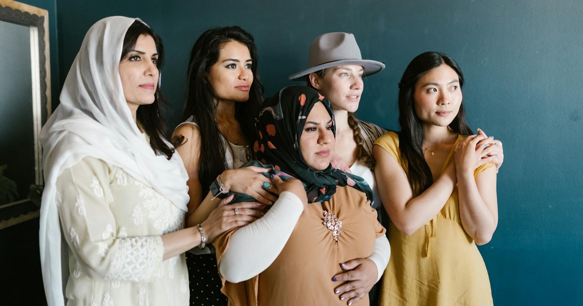 A group of diverse women embracing and supporting each other, symbolizing empowerment and unity.