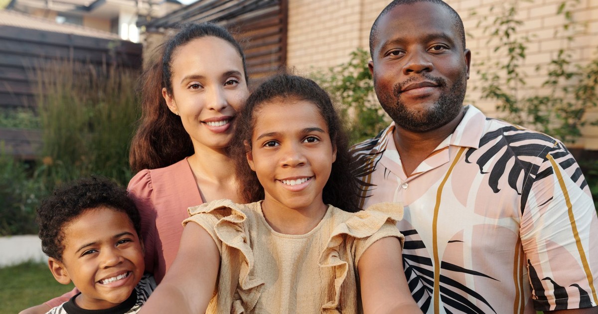 Portrait of a joyful multicultural family smiling together in the garden.