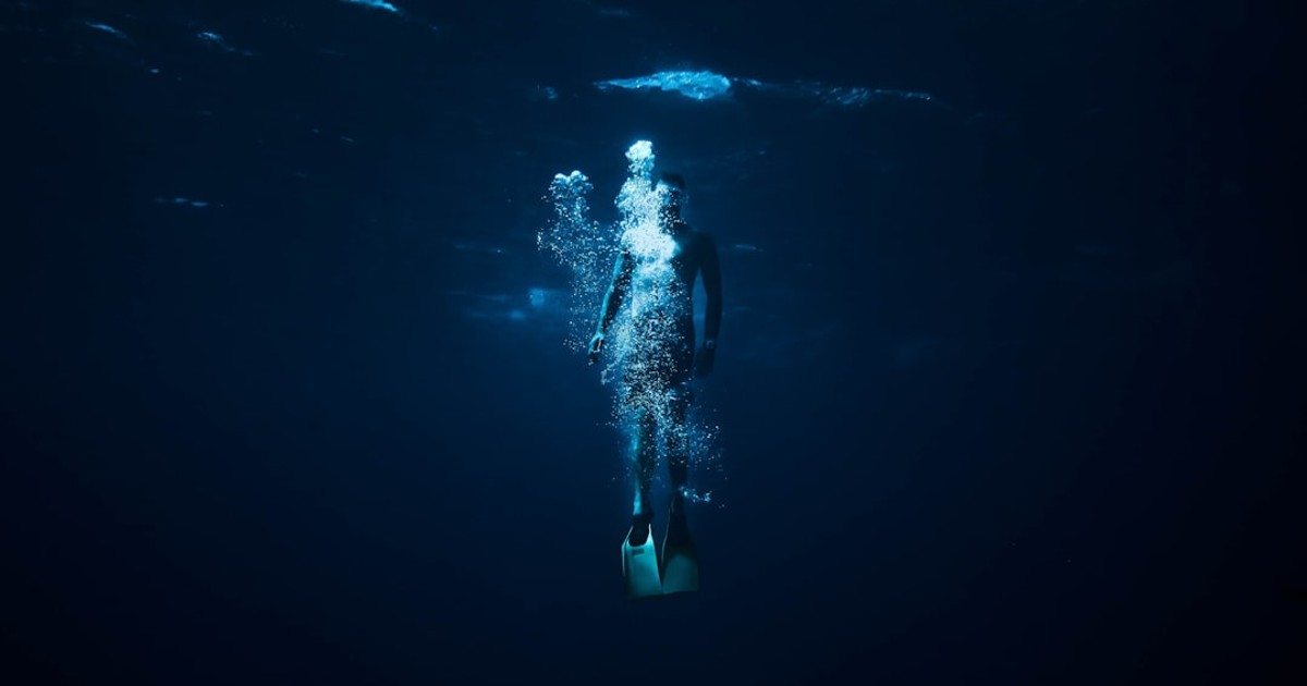 person diving on body of water
