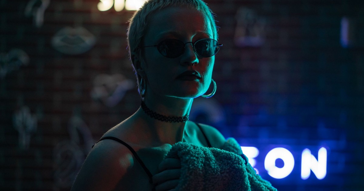 Backlit portrait of a fashionable woman in neon lighting, exuding a stylish and edgy vibe.