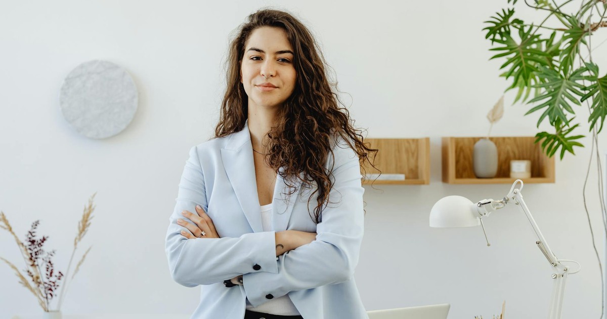 Professional woman with curly hair exuding leadership in a contemporary office environment.