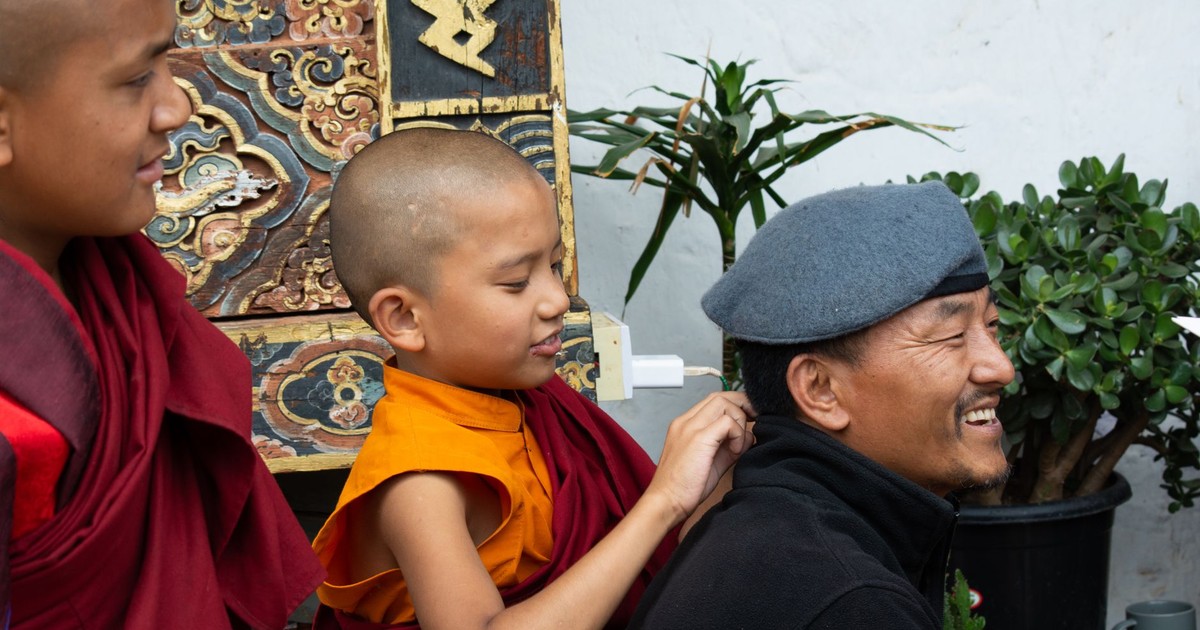 Young Buddhist monks laughing together in traditional attire, capturing the essence of Bhutanese culture.