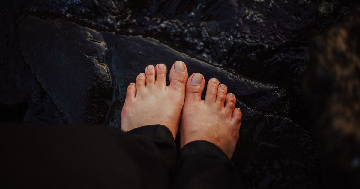 Close-up of feet on wet rocks, embracing natural textures and a connection to earth.