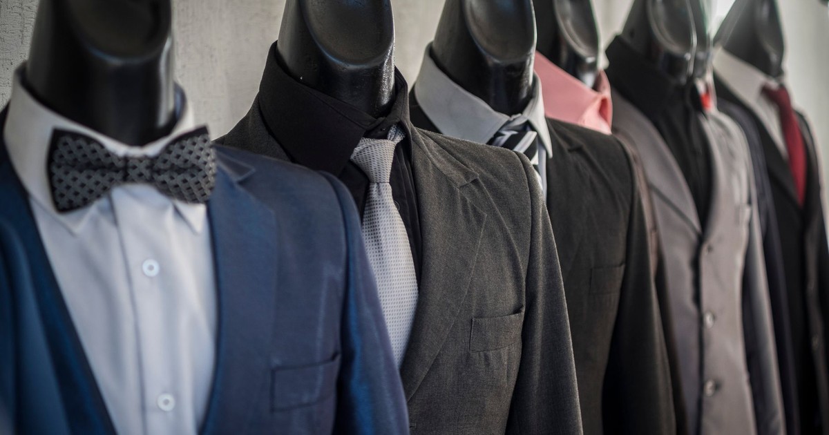 Close-up of mannequins adorned in elegant men's suits in a store setting, showcasing diverse styles.