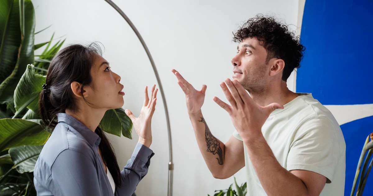 A couple argues indoors amidst greenery, showcasing emotions and interpersonal conflict.
