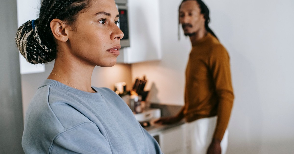 Black lady and guy standing in kitchen at home and having conflict while arguing