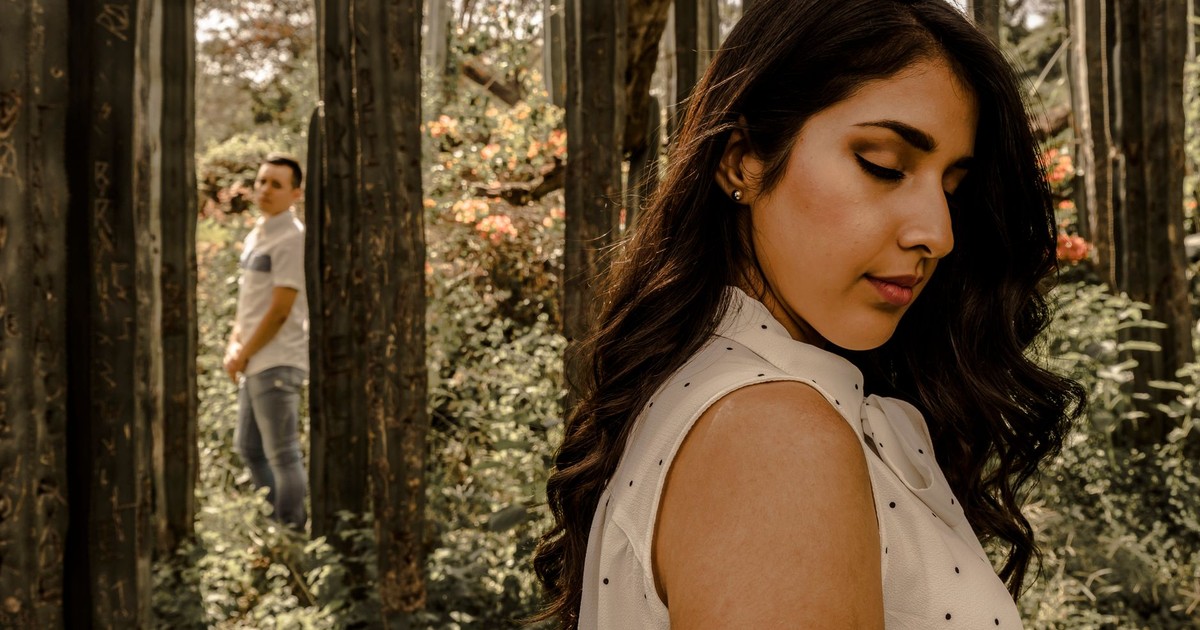 A man and woman in a forest exhibit emotions of love and separation.