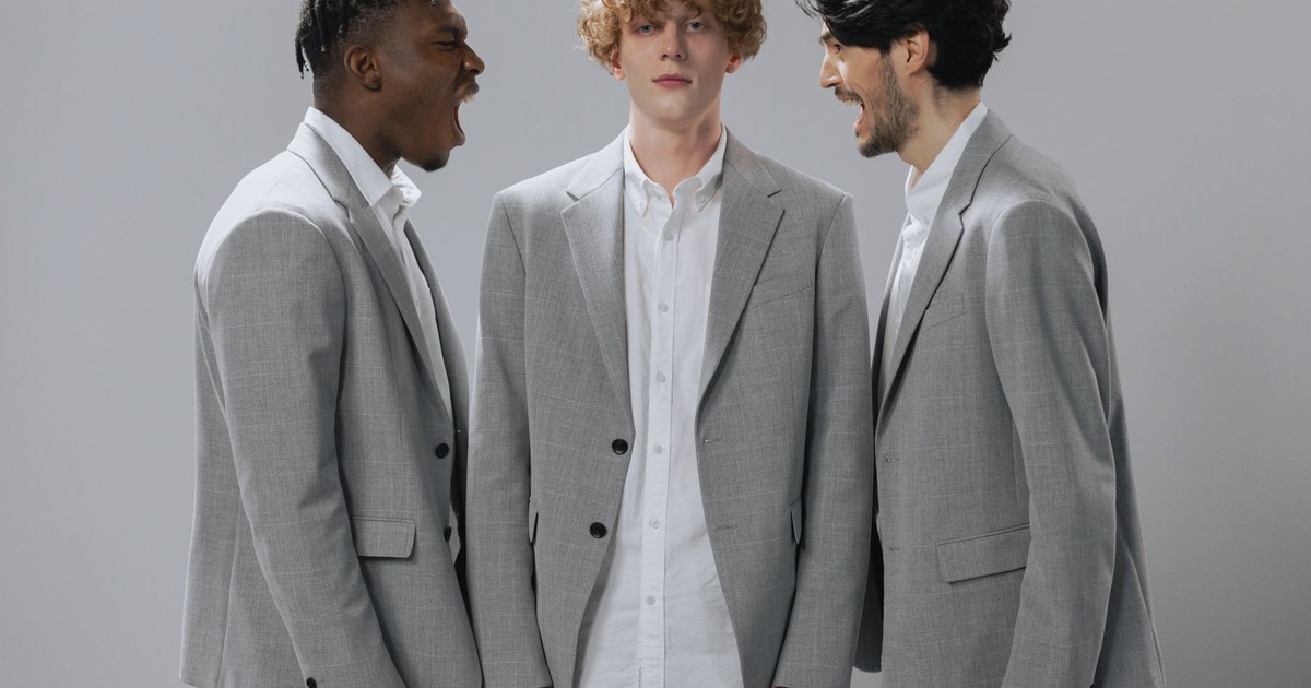 Three men in gray suits demonstrating conflict in a professional setting.