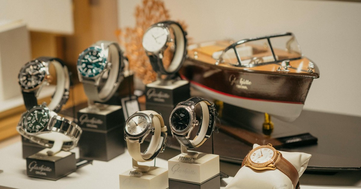 A collection of luxury watches elegantly displayed beside a model boat in a retail environment.