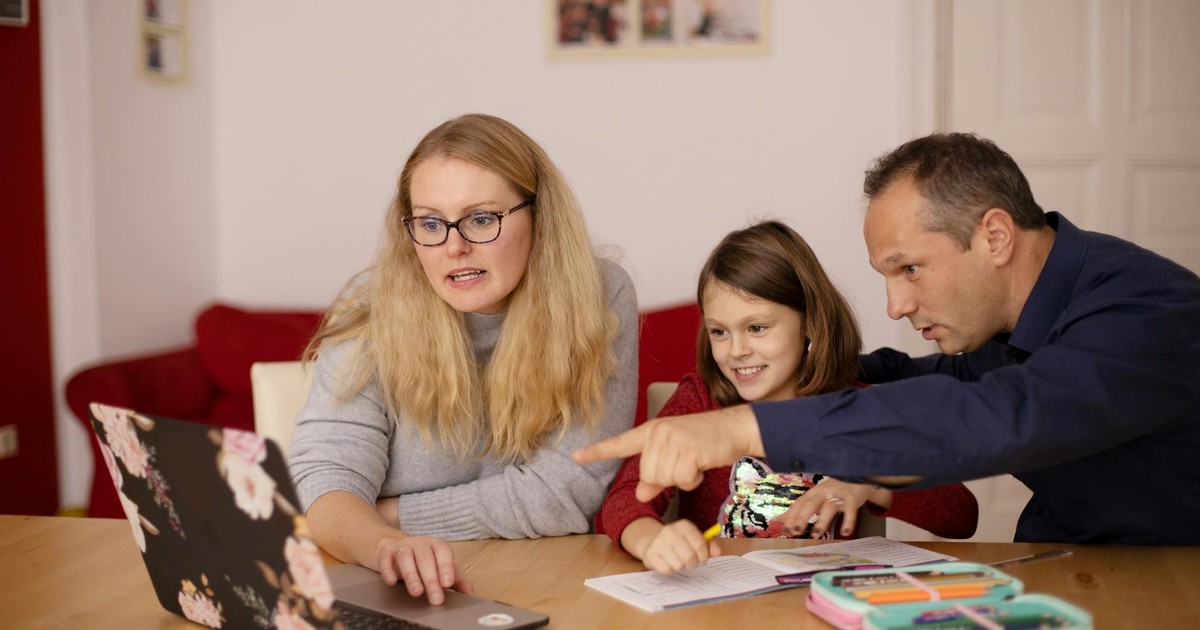 A family learning together with a laptop at home, emphasizing collaboration and education.