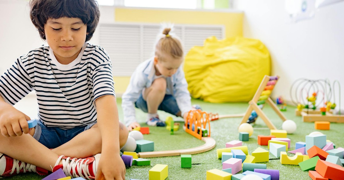 Kids enjoying playtime with toys and blocks in a bright kindergarten classroom.
