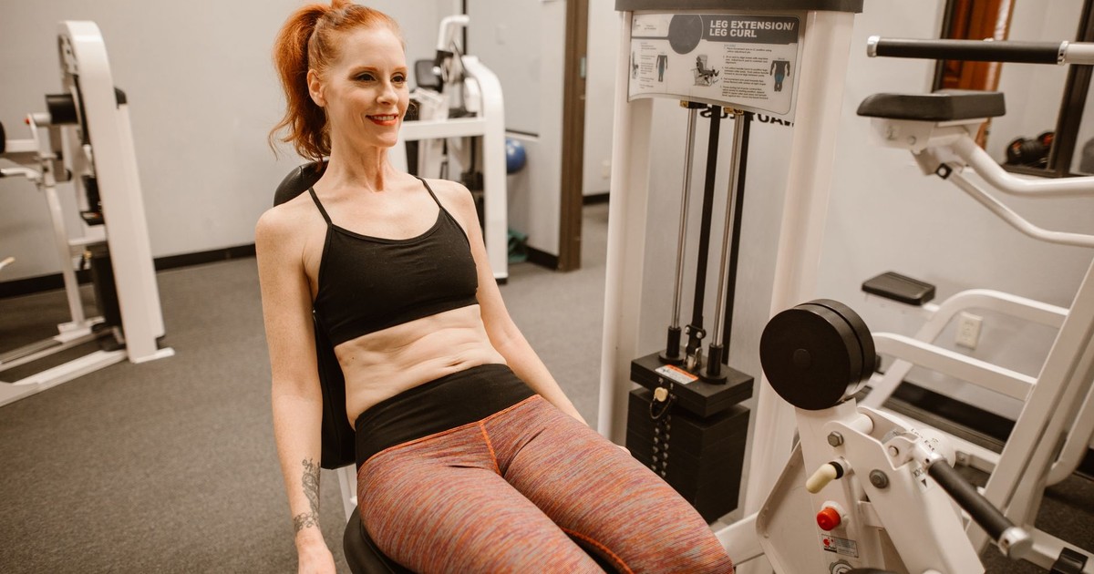 Woman performing leg workout in gym, showcasing fitness and health lifestyle.