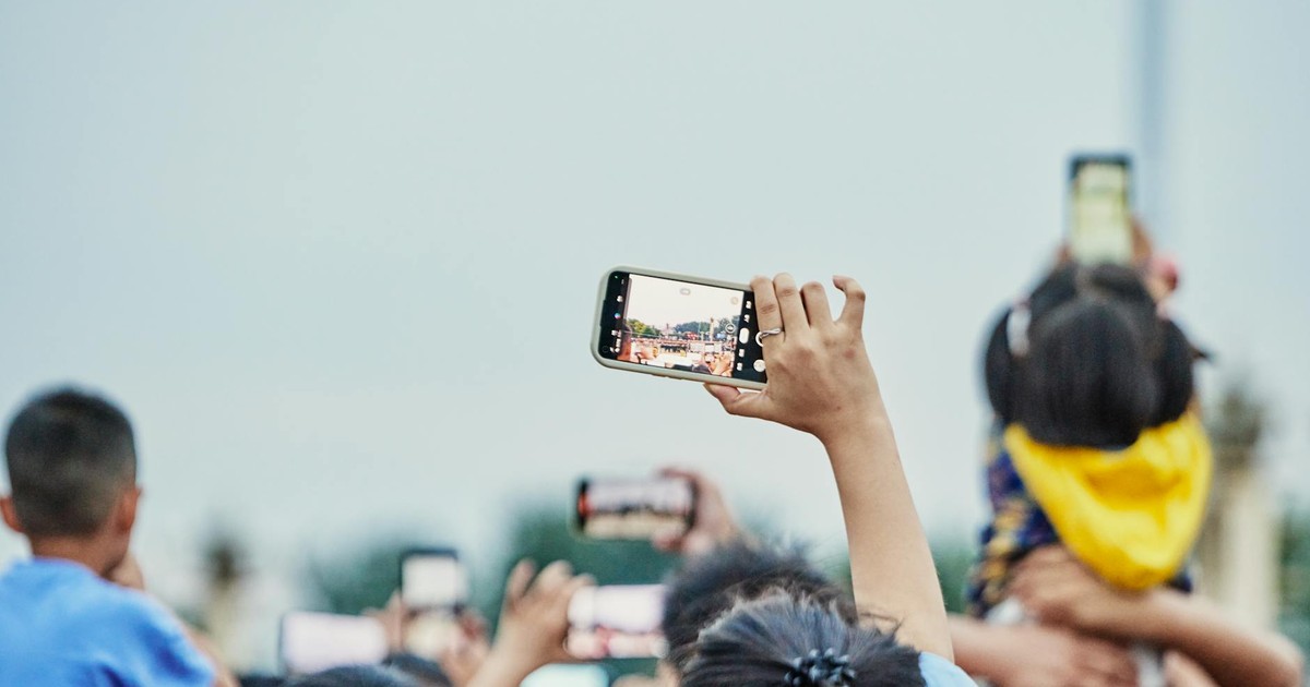 A lively crowd capturing an event on smartphones, showcasing modern digital engagement.