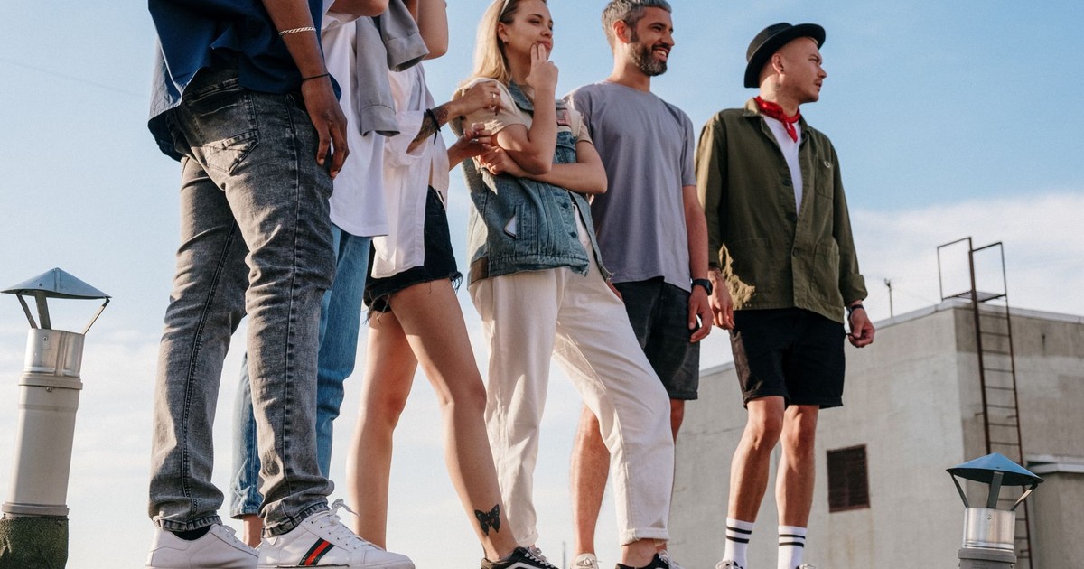 Group of young adults enjoying a sunny day on a rooftop, embodying urban leisure and friendship.
