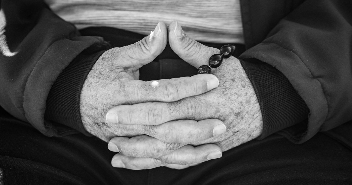 Close-up of senior hands with prayer beads, symbolizing reflection and tranquility.