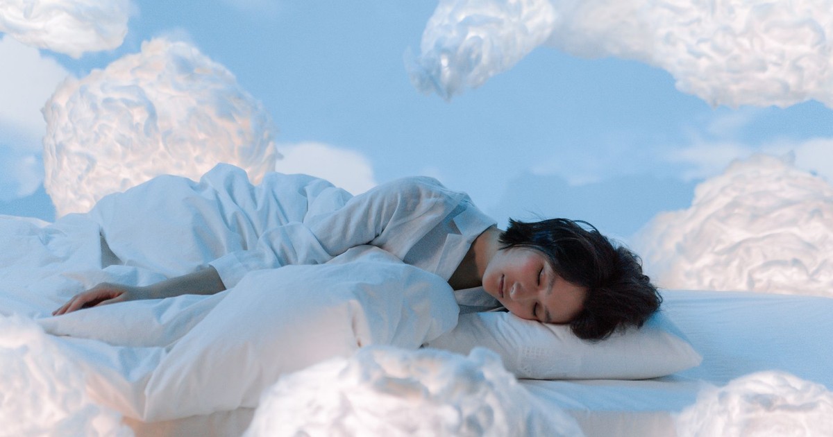 A serene and imaginative portrayal of a woman sleeping surrounded by fluffy clouds.