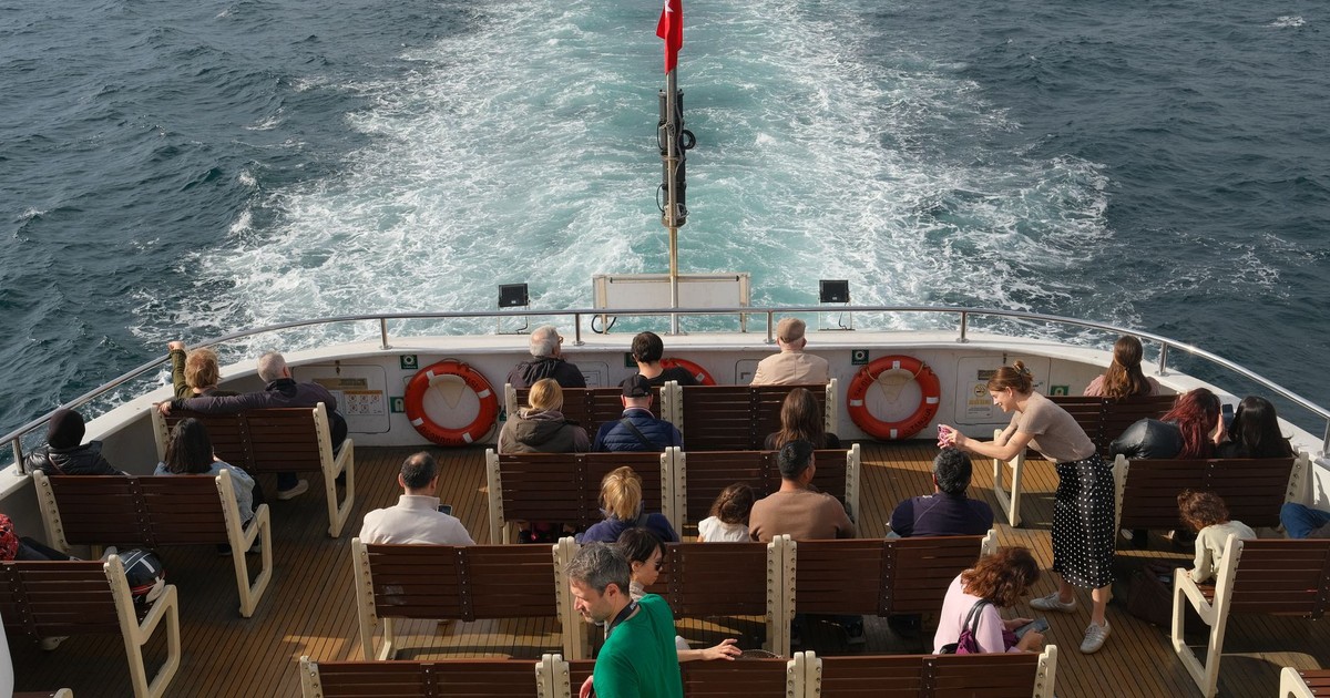 A diverse group of people enjoy a sunlit boat ride, showcasing movement and leisure.