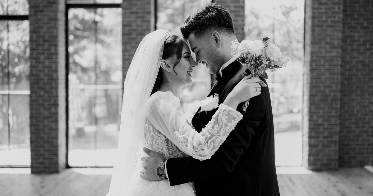 Newlyweds sharing a joyful embrace in a beautiful hall.