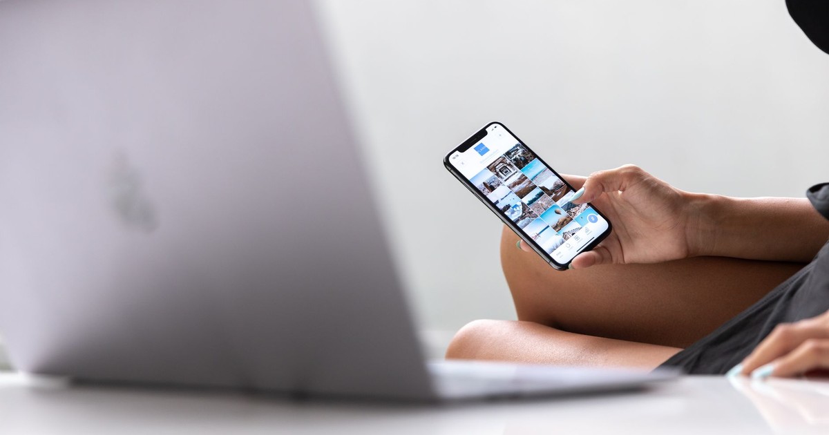 A woman multitasks using a smartphone and laptop, symbolizing modern digital nomad lifestyle in Bali.