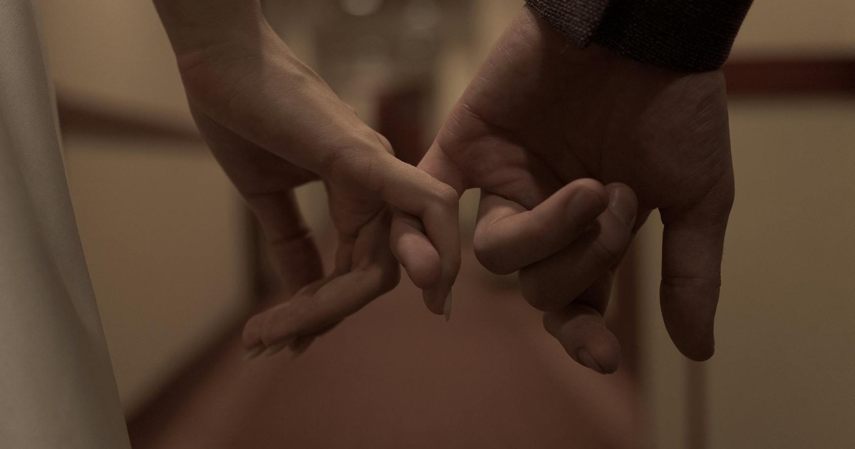 Tender close-up of two hands holding each other, symbolizing love and connection.