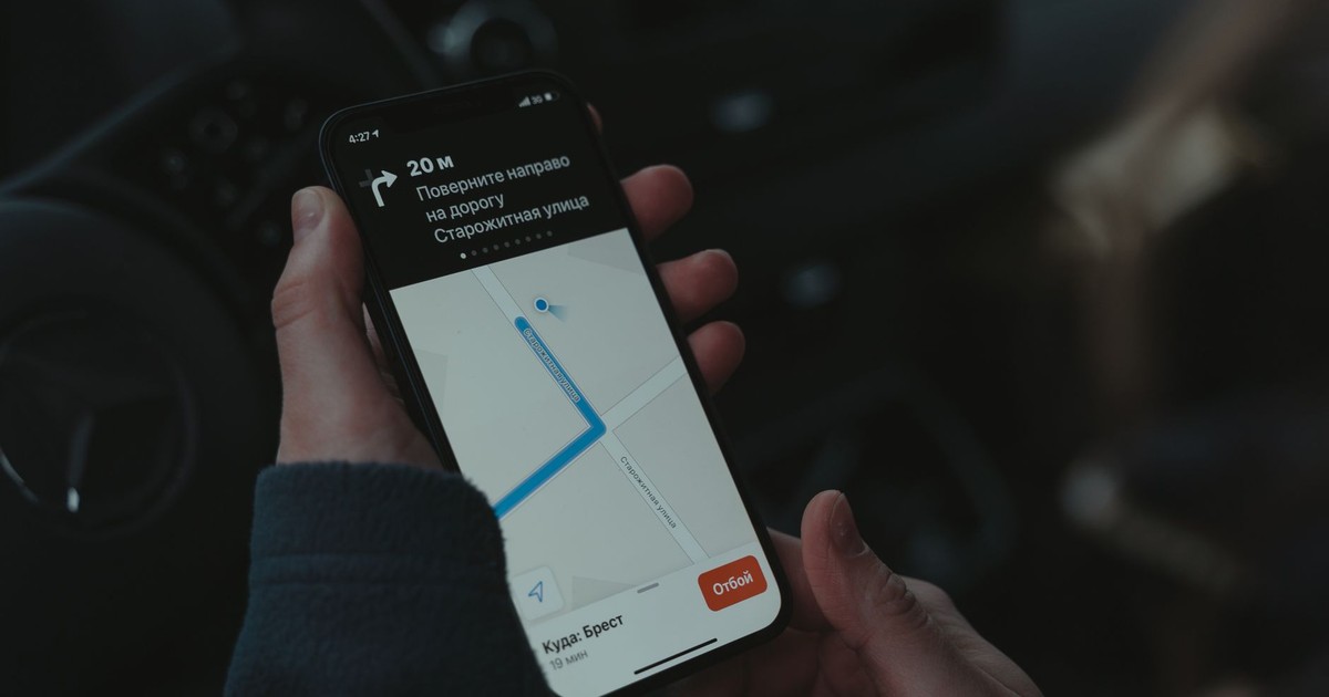 Close-up of a smartphone displaying a navigation app in a car, highlighting modern technology use while driving.