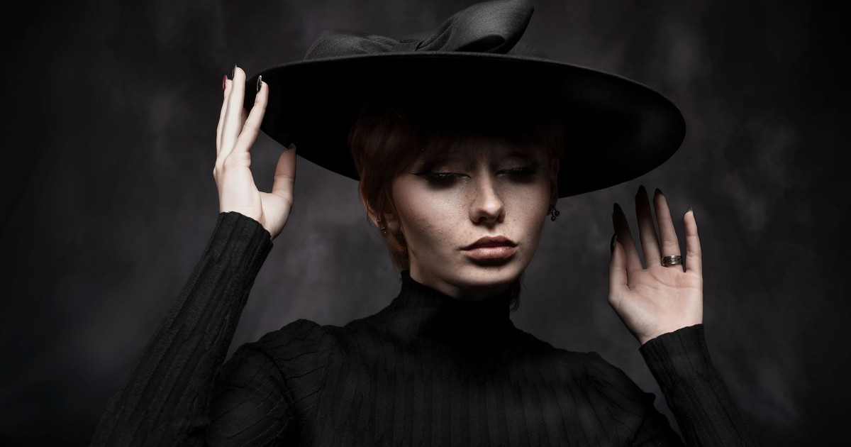 Stylish portrait of a woman wearing a wide-brimmed black hat, exuding elegance.